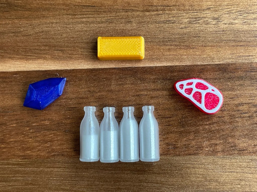 image showing different levels of milk in 3d printed milk resource tokens for Wyrmspan
